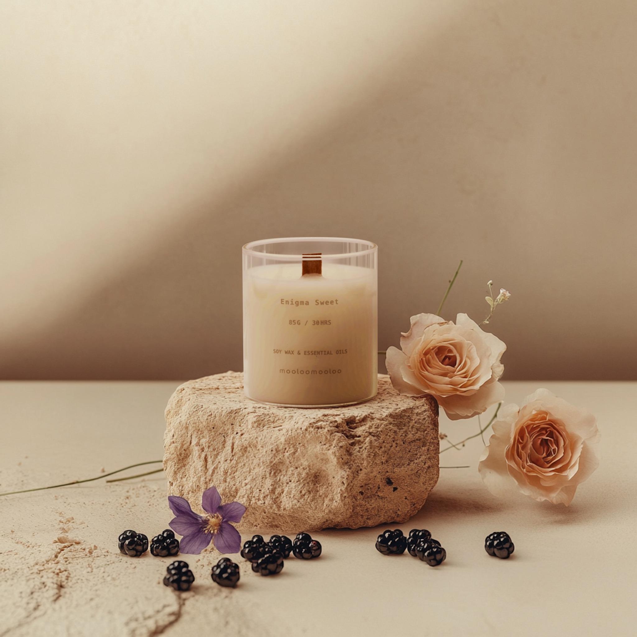 Enigma Sweet scented candle on textured stone with floral accents – elegant home fragrance decor